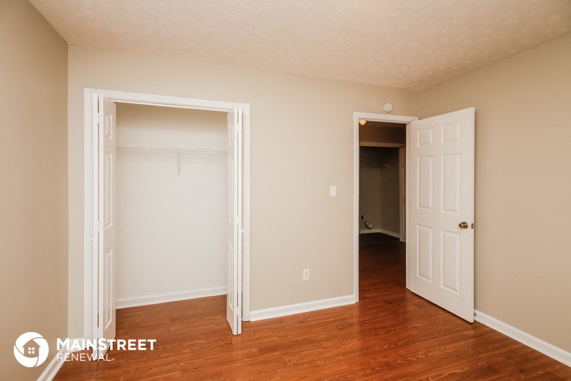 a bedroom with a closet and a door to a hallway