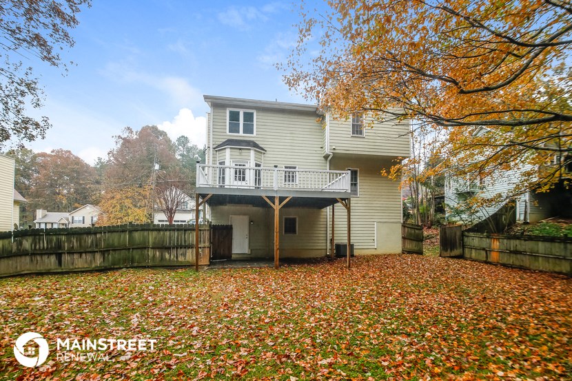 a house with a yard with fall leaves on the ground