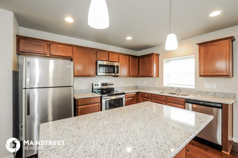 an updated kitchen with granite countertops and stainless steel appliances