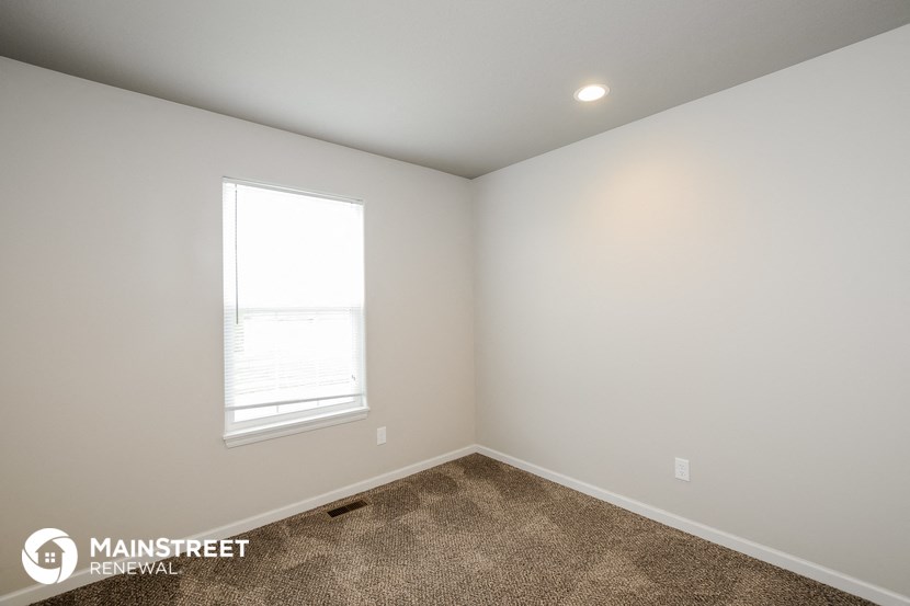 the bedroom of a new home with carpet and a window