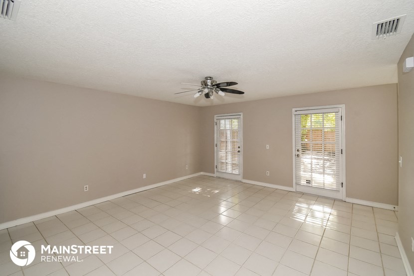 an empty living room with a ceiling fan