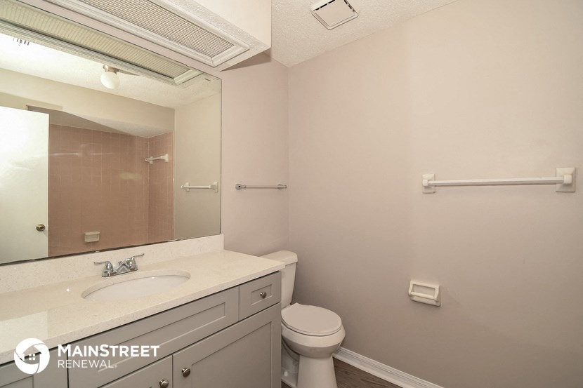 a bathroom with a sink and a toilet and a mirror