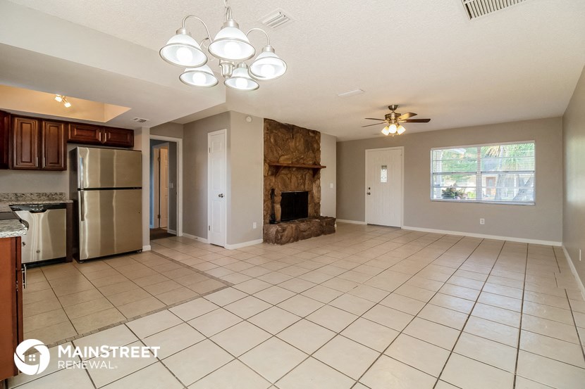 a large living room with a fireplace and tile flooring