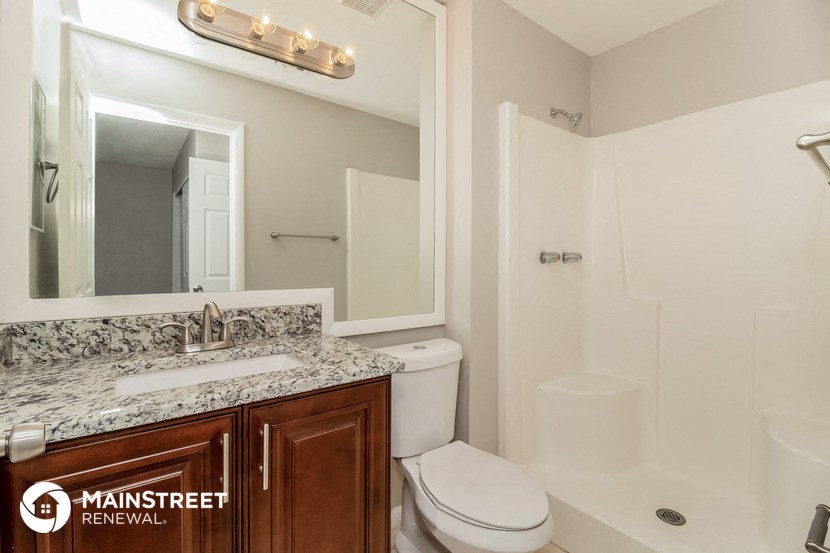 a bathroom with a toilet and a sink and a mirror