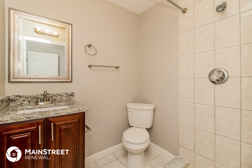 a bathroom with a toilet and a sink and a mirror