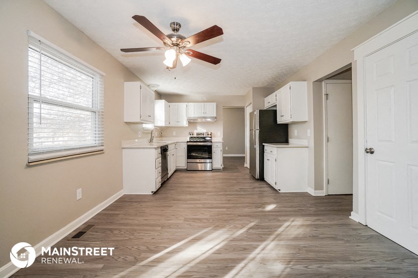 a kitchen with white cabinets and a ceiling fan