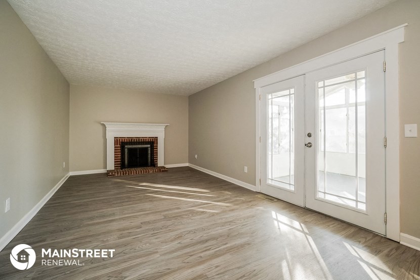 the living room with fireplace and doors
