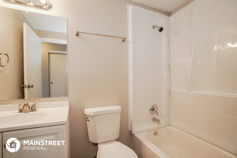 a bathroom with a shower toilet and sink and a mirror