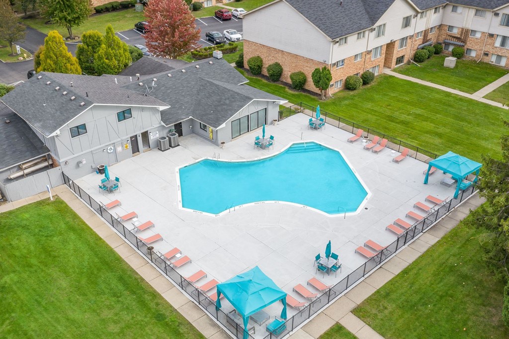 an aerial view of a swimming pool in the backyard of a house