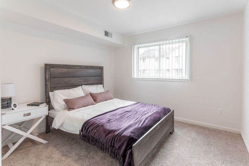 a bedroom with a bed and a window