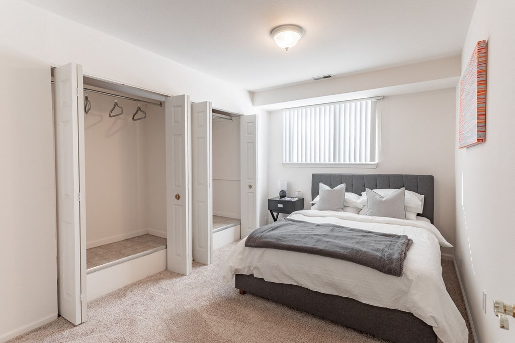 a bedroom with a bed and a closet and a window