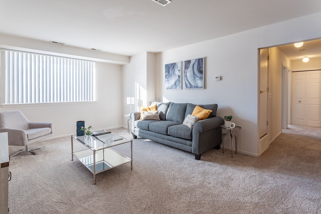 a living room with a couch and a glass coffee table