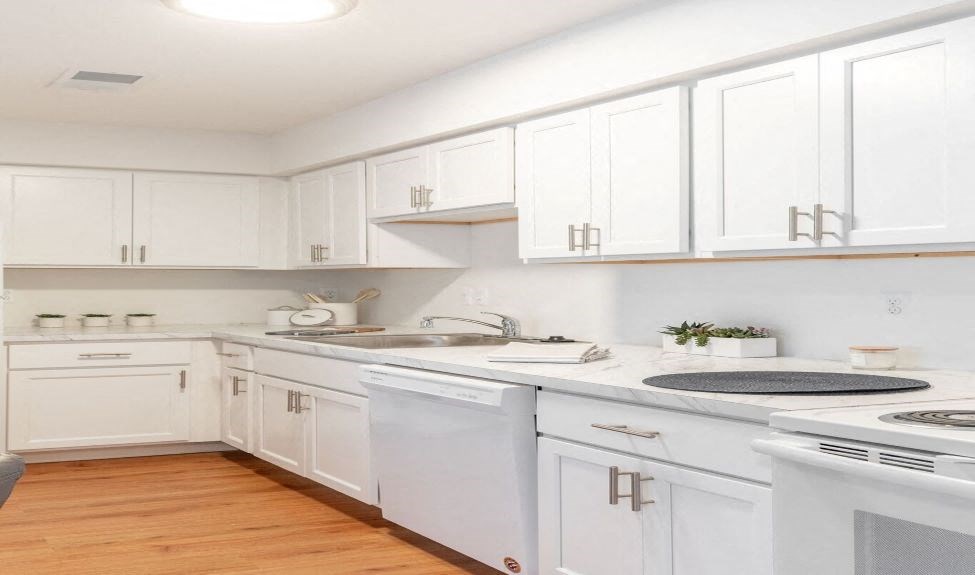a kitchen with white cabinets and a stove and a sink
