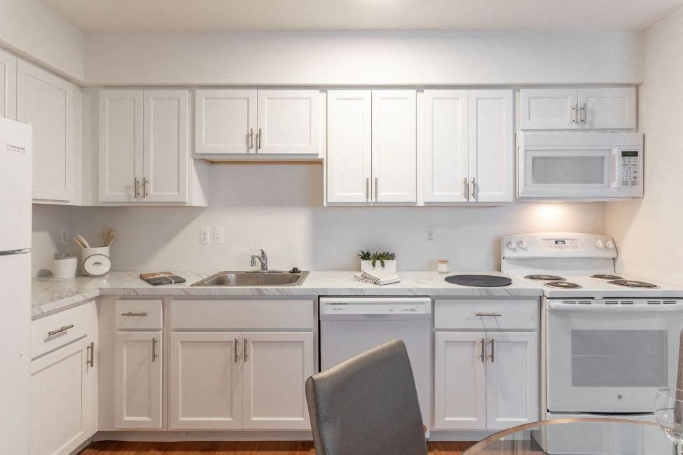 a white kitchen with white appliances and white cabinets