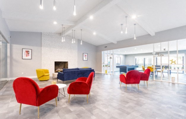 a living room with red chairs and a fireplace