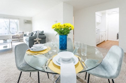 a dining room with a glass table and chairs