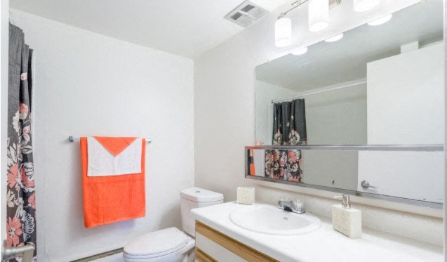 a bathroom with a sink toilet and a mirror