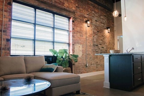 an exposed brick wall in a living room with a couch and a table