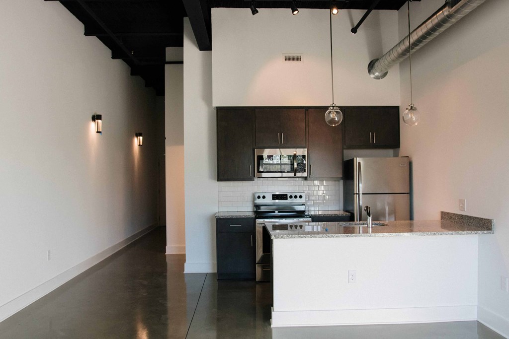 a kitchen with an island and a stainless steel refrigerator