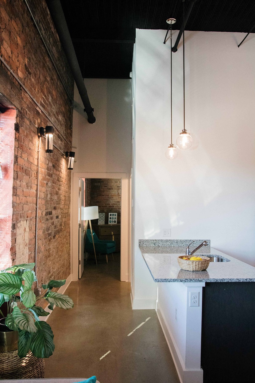a kitchen and living room with a brick wall