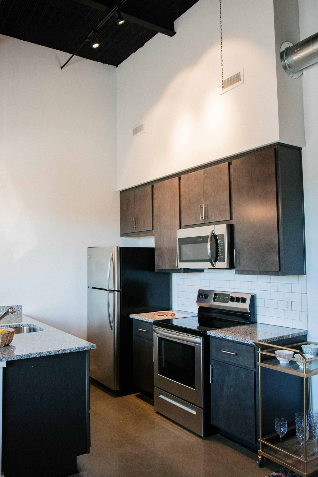 a kitchen with stainless steel appliances and black cabinets