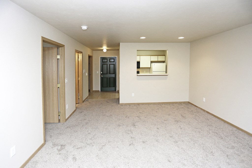 an empty living room with white walls and a white carpet