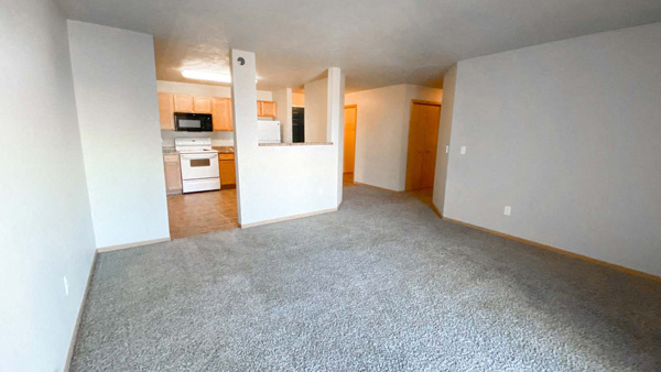 Living room at Amber Valley in Fargo ND with a view of the kitchen and entry way hallway