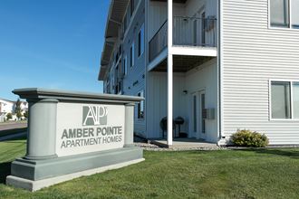 Exterior of Amber Pointe with an outside monument and view of the deck and patio