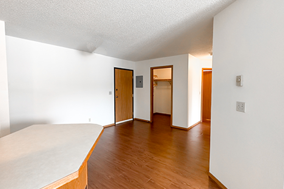 an empty living room with wood floors and white walls