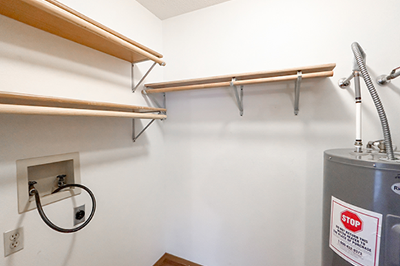 a laundry room with a washer and dryer and shelves on the wall
