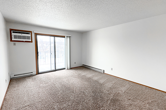 an empty living room with a door to a balcony