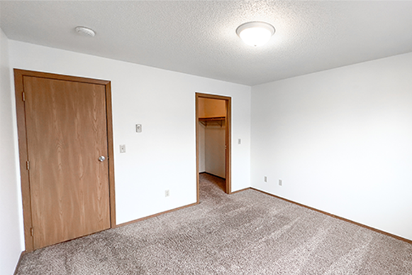 an empty living room with a door to a hallway