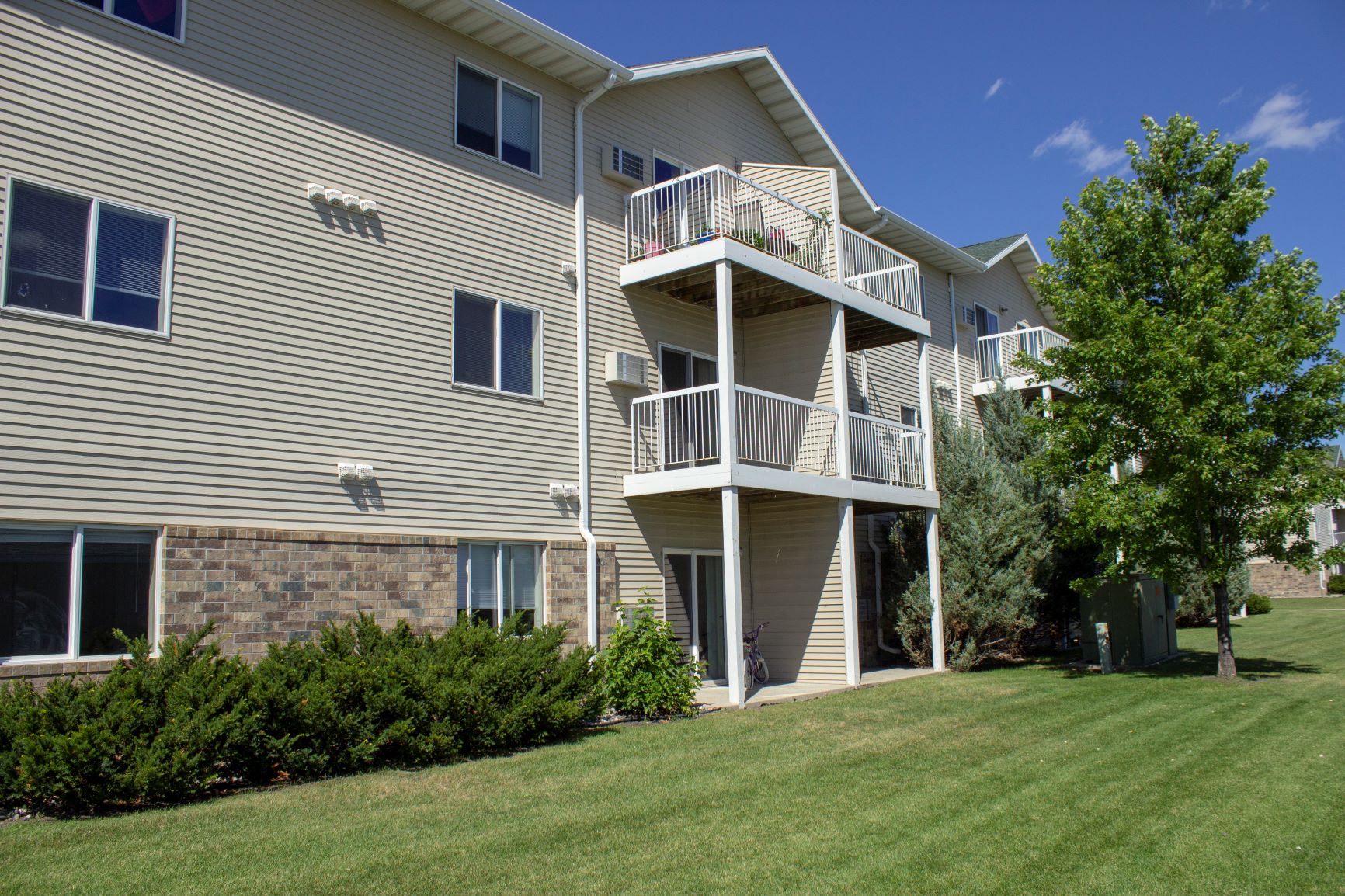 Exterior of Amber Fields with green lawn, view of balconies and patios