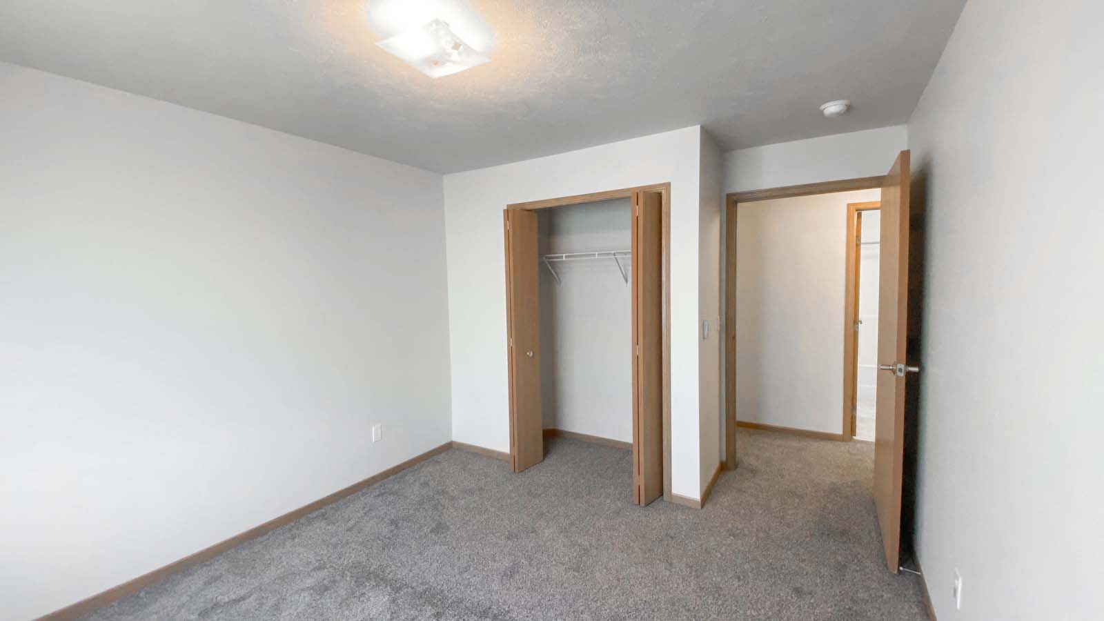 Guest room at Amber Fields with view of the hallway, carpet flooring, and full closet