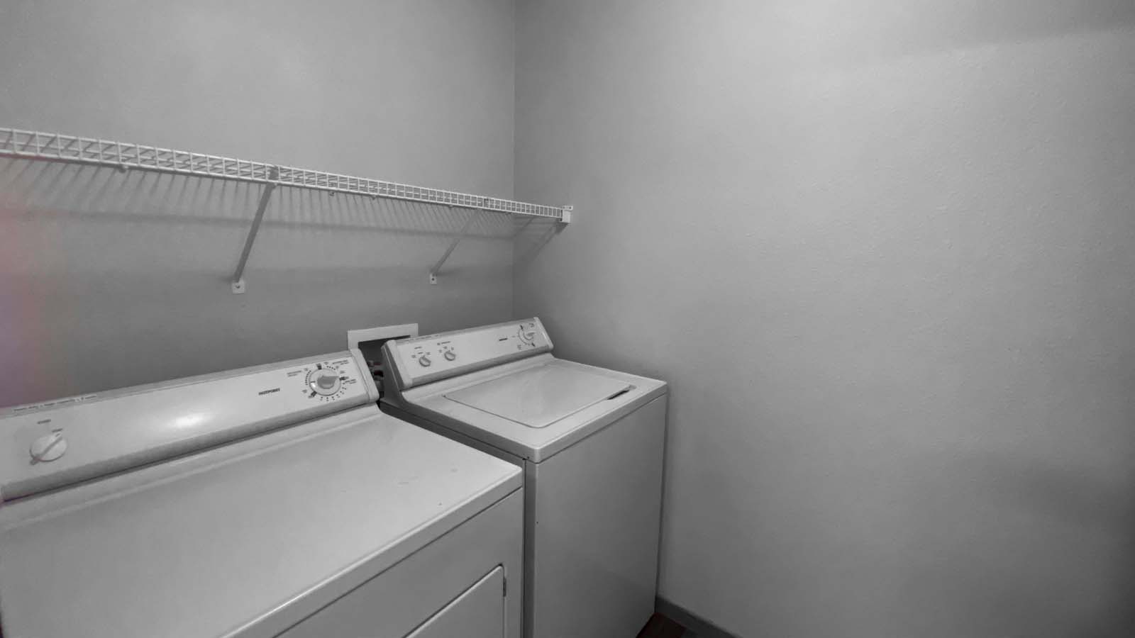 In-unit washer and dryer with shelves in a spacious room at Amber Fields