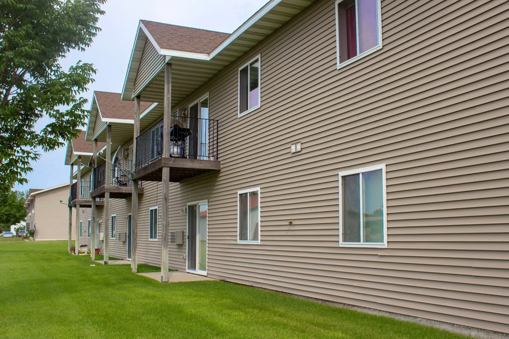 a view of the outside of a building with green grass