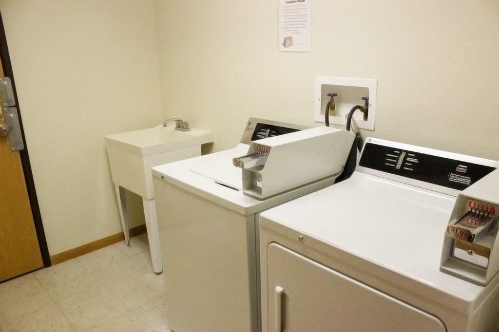 two washing machines and a sink in a laundry room