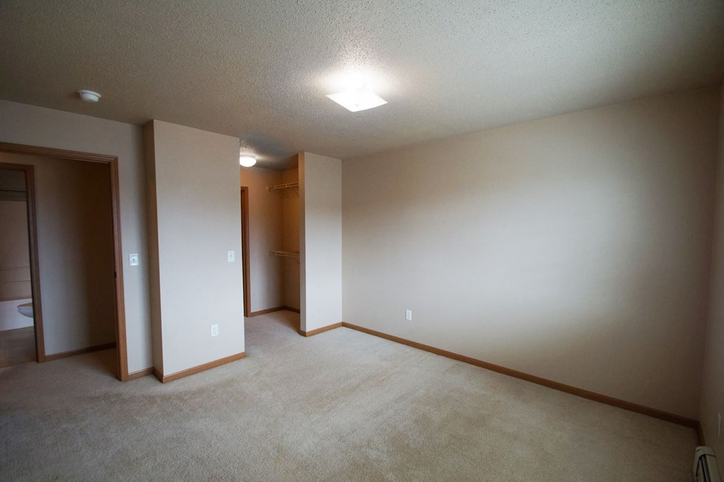 an empty living room with white walls and a closet