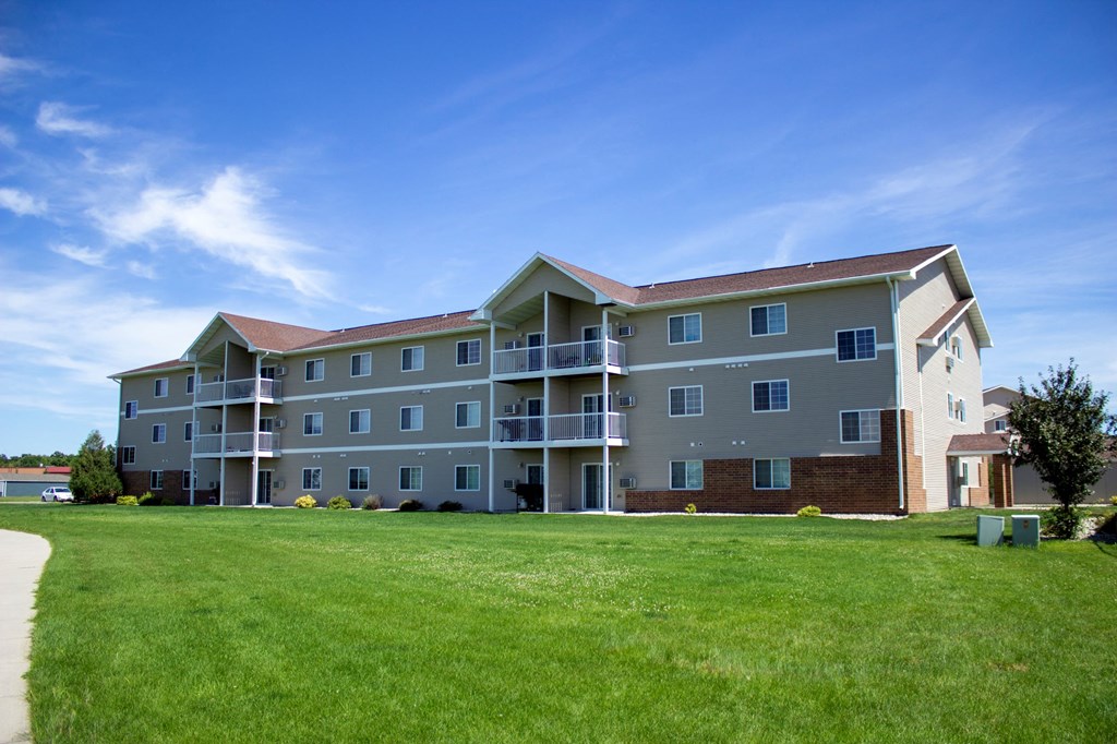 a large building with a green lawn in front of it