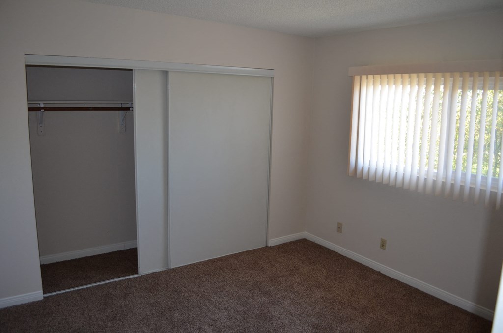 a bedroom with a closet and a window