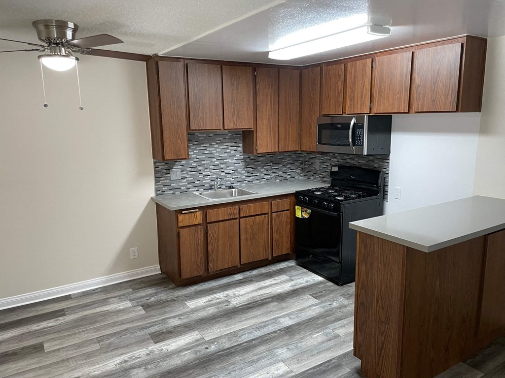 a kitchen with wooden cabinets and a stove and a sink