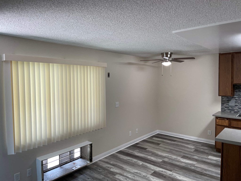 a living room with a window and a ceiling fan
