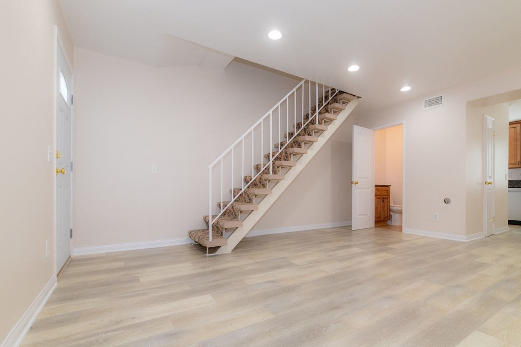 A room with a staircase and wooden flooring.