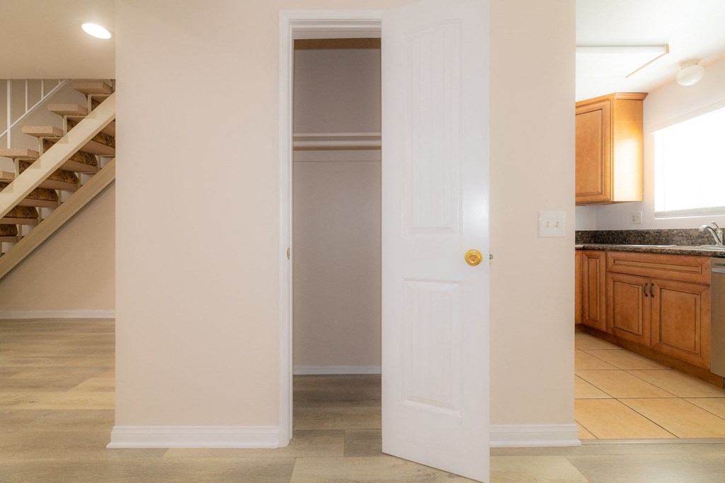 A white door is open to a kitchen area.