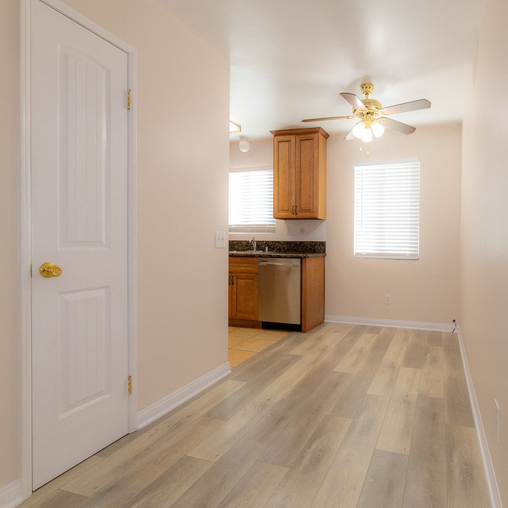 A kitchen with a white door and a fan on the ceiling.