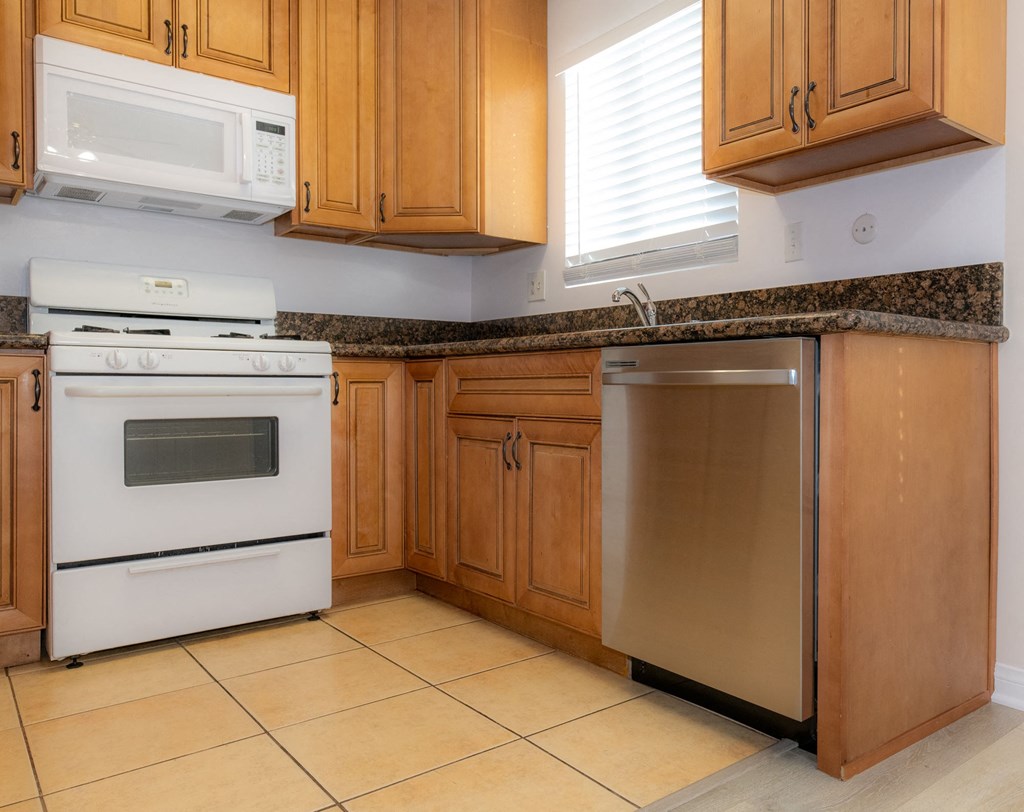 A kitchen with wooden cabinets and a white oven.
