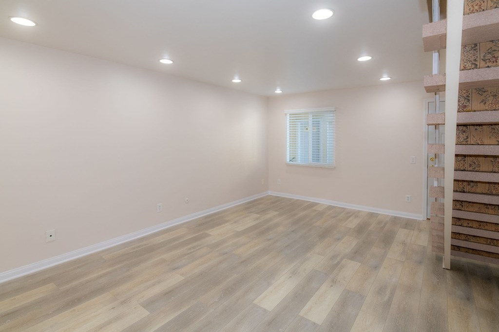 A room with wooden flooring and a window.