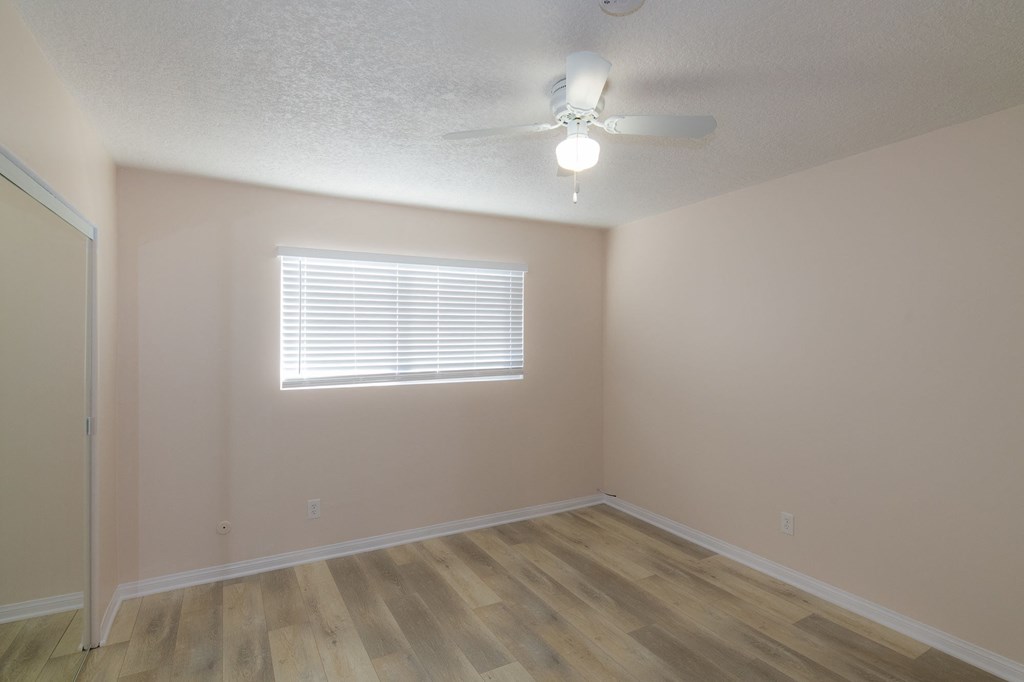 A room with wooden flooring and a ceiling fan.