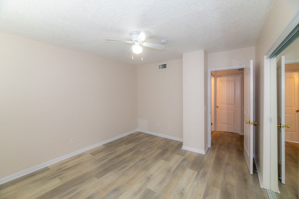 A room with a wooden floor and a ceiling fan.