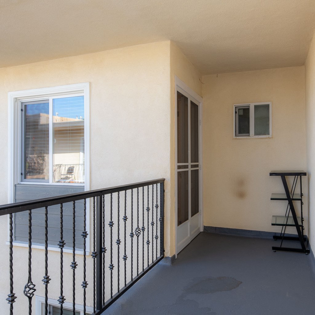A balcony with a black railing and a small table.